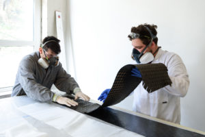 Florian and Fabrice lay a second layer of carbon fiber